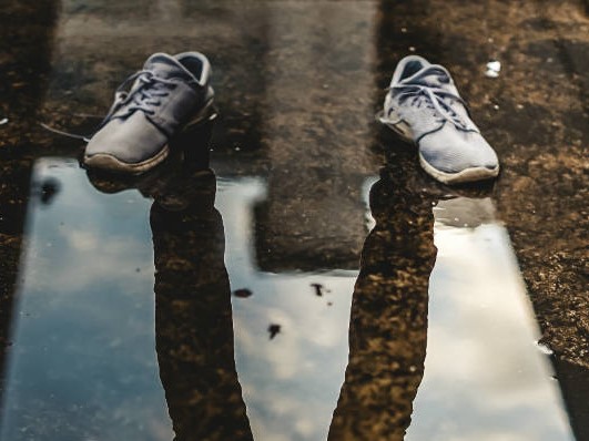 Reflection of man in puddle